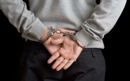 Man in handcuffs on black background