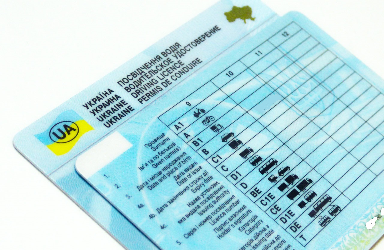 Ukrainian driving license with UA logo, blue card, and vehicle category grid.
