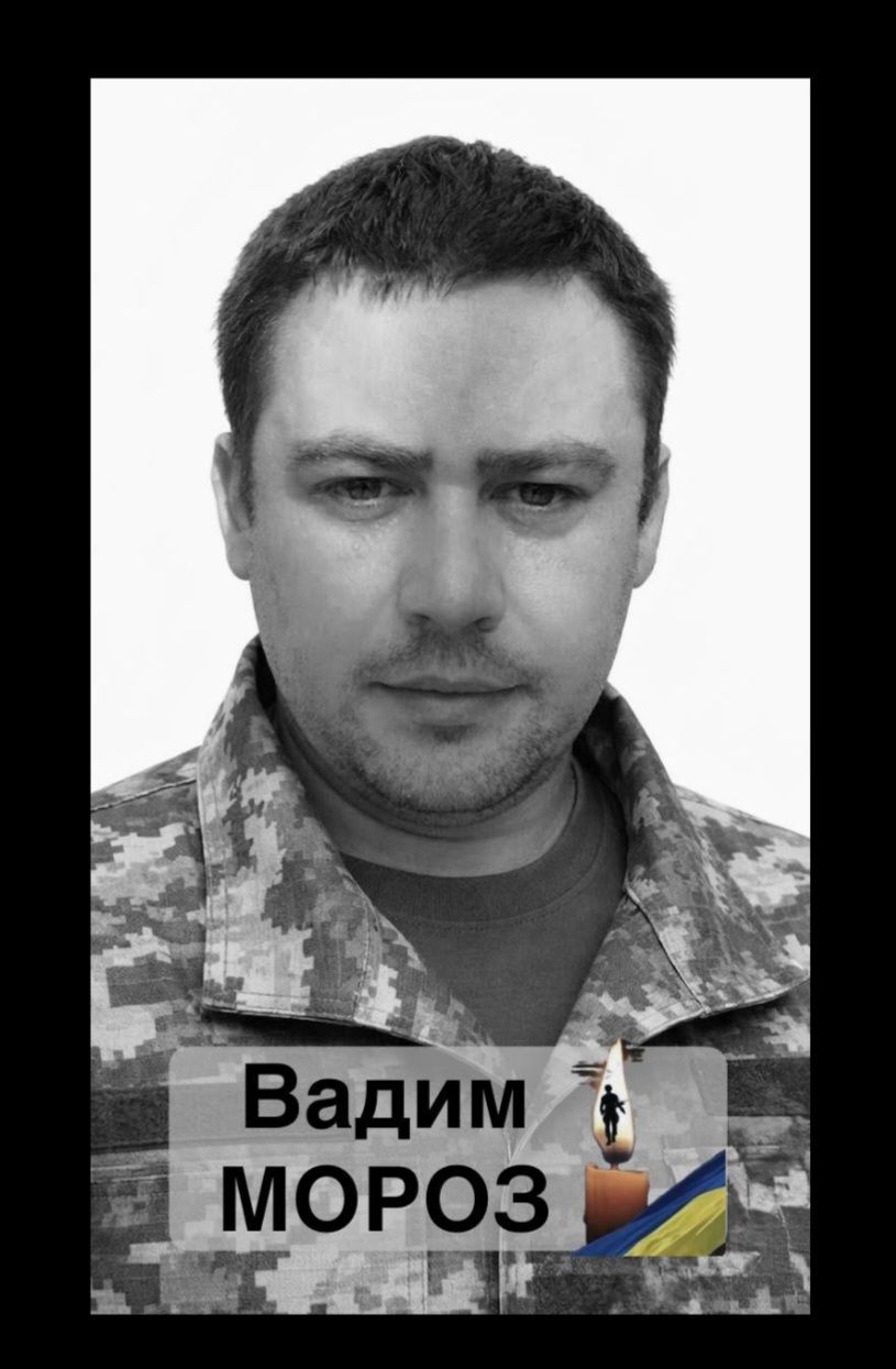 Portrait of Vadim Moroz in camouflage, with a memorial candle and Ukrainian flag imagery in the foreground.