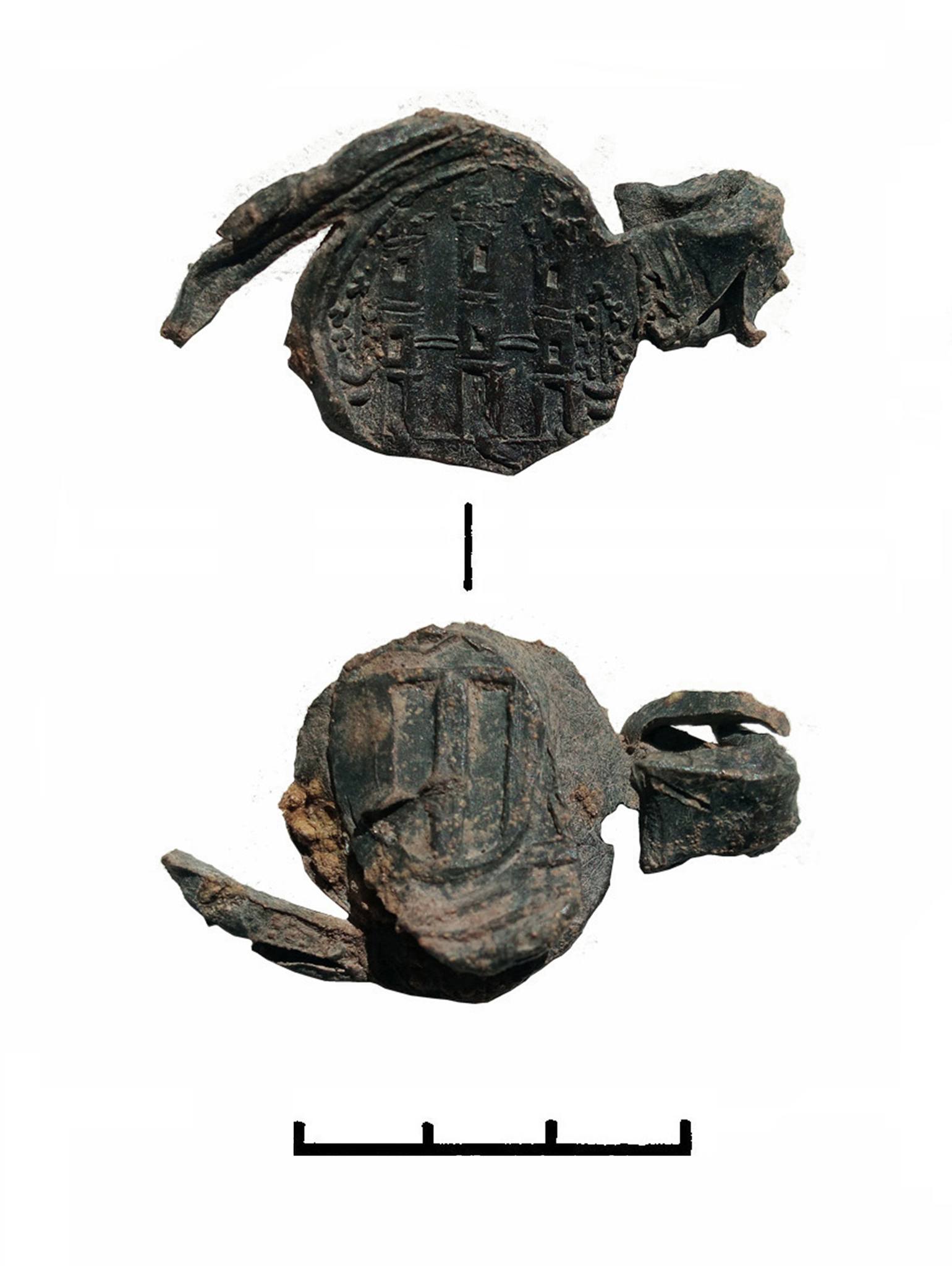 Ancient clay seal fragment with cuneiform-like inscriptions and a measurement scale below for reference