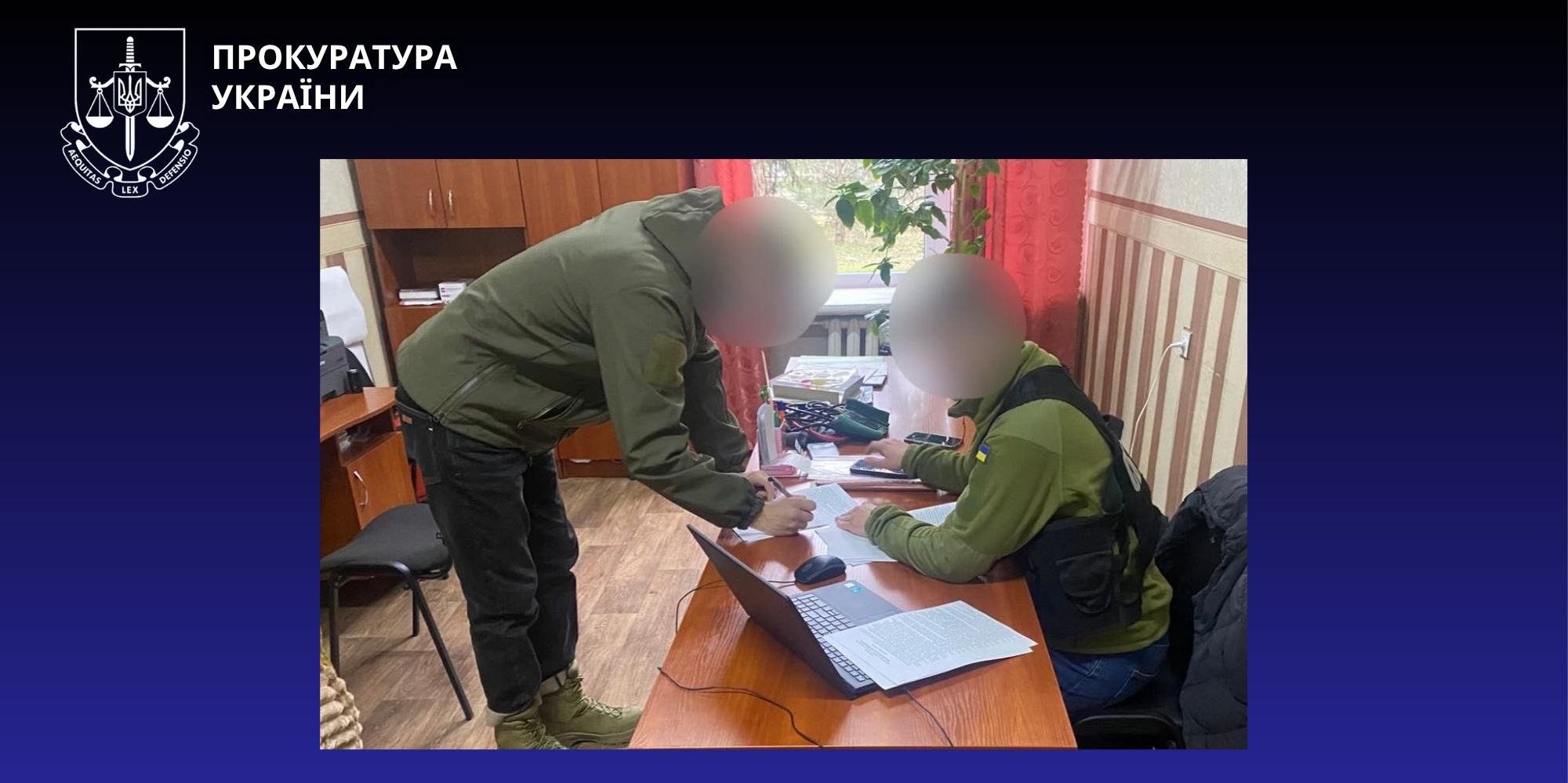Two people in green uniforms sign documents at a wooden desk in an office, with a laptop and scattered papers nearby (faces blurred).