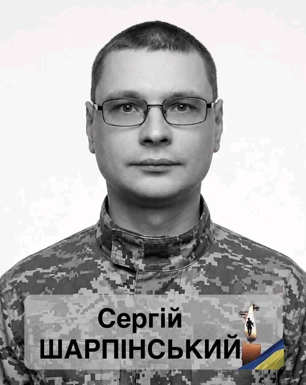 Portrait of a man in digital camouflage with glasses; name badge reads Сергій ШАПРІНСЬКИЙ.