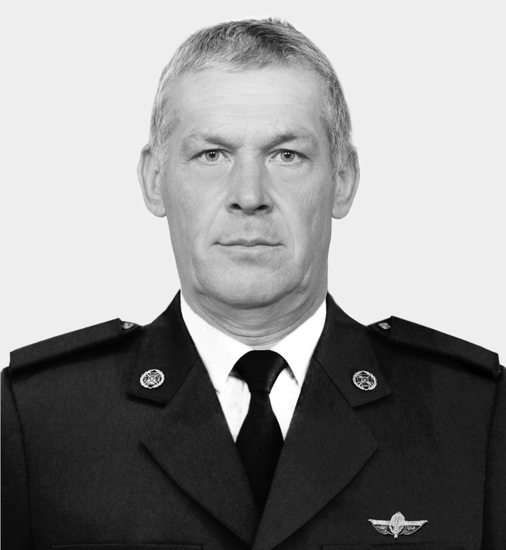 Portrait of a male military officer in formal dress uniform, stern expression, gray hair, wings badge on chest.