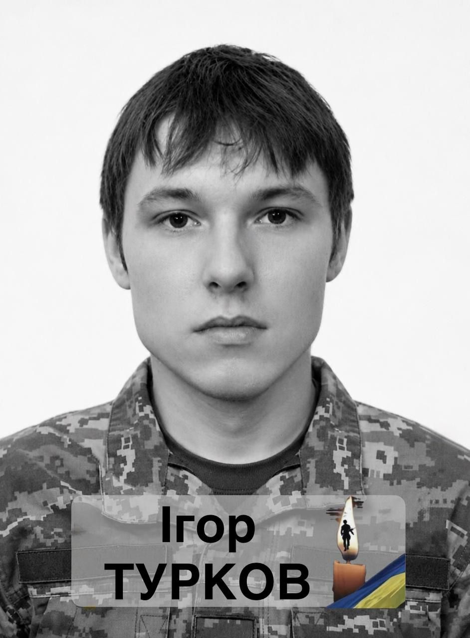 Black-and-white portrait of a young man in camouflage uniform, with a translucent banner showing the name Ігор Турков and a small candle with Ukrainian flag.
